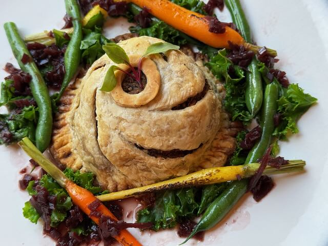 Gourmet pie with vegetable garnish on a white plate at Strewn Winery.