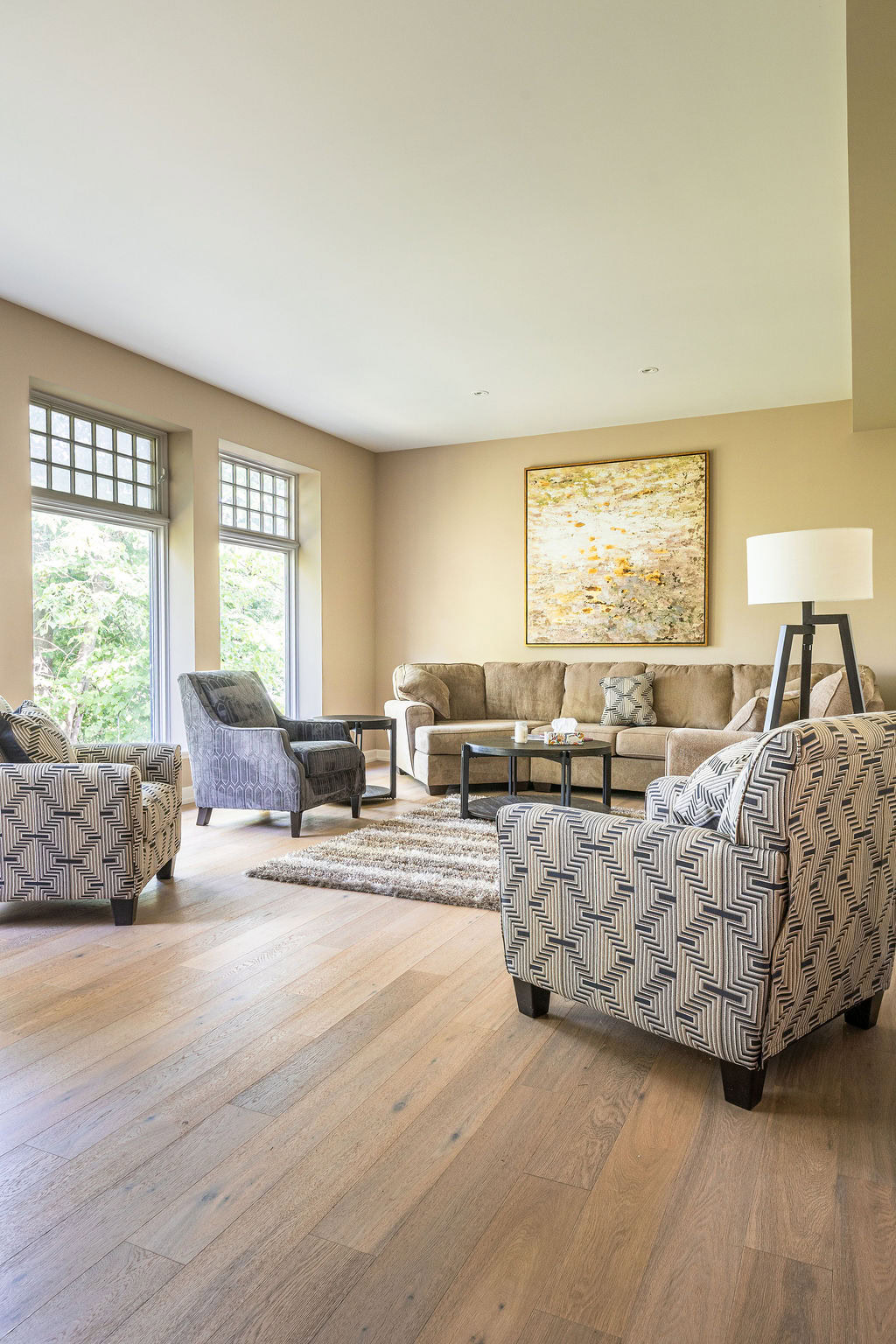 Elegant living room with comfortable armchairs, sofa, large windows, and modern decor at Strewn's vacation rental.