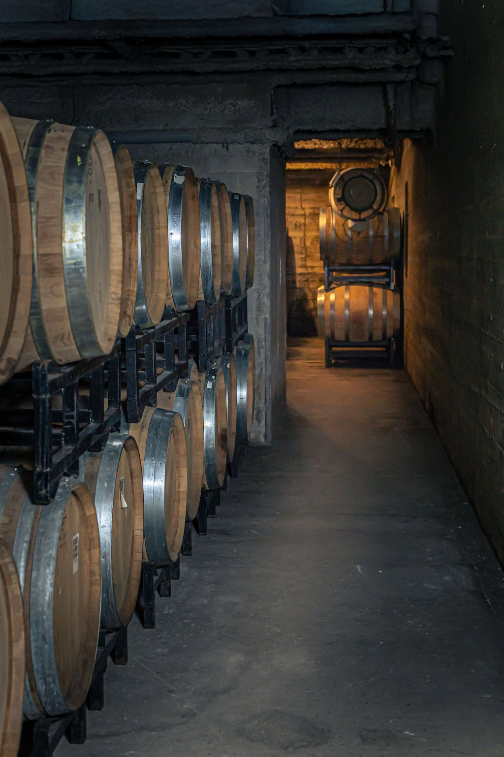 Wine barrels stored in a cellar at Strewn Winery, showcasing traditional aging process.