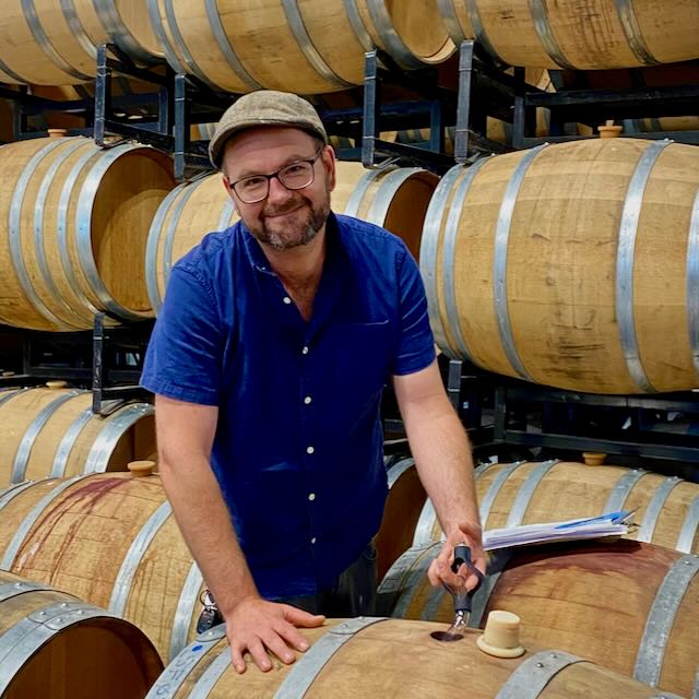 Winery staff inspecting wine barrels at Strewn Winery in a cellar.